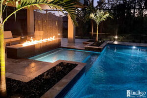 pool at night with waterfall and firepit